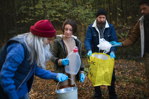 A diverse group of volunteers cleaning up forest from waste, community service concept