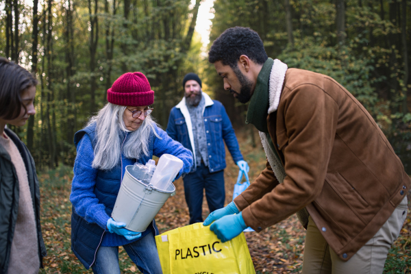 A diverse group of volunteers cleaning up forest from waste, community service concept