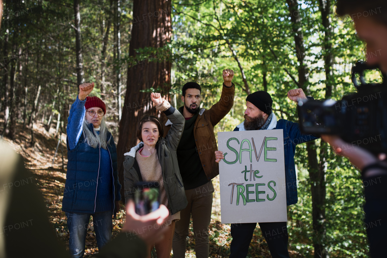 A diverse group of environmental activists with banner protestig against illegal construcion in forest