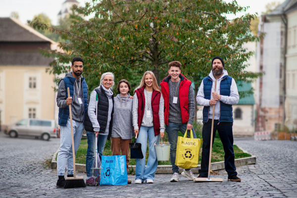 A group of happy volunteers looking at camera, ready to clean up street, community service concept