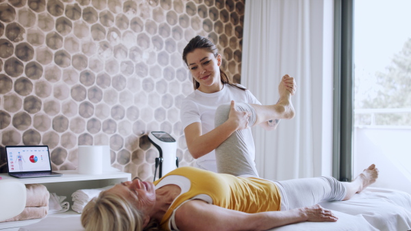 A senior woman in physiotherapy in resort with female therapist.