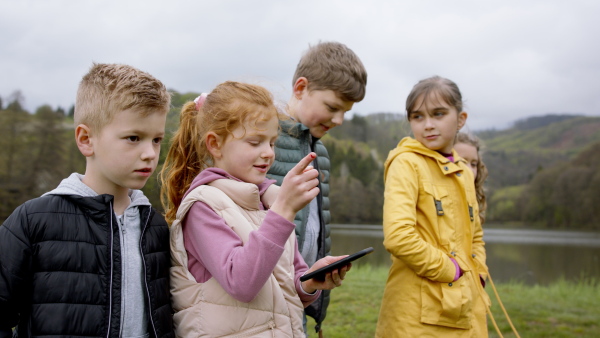 Group of small children outdoors in nature, looking for direction. Learning group education concept.