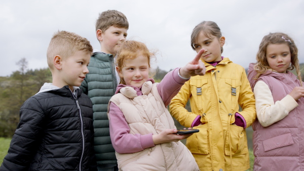 Group of small children outdoors in nature, looking for direction. Learning group education concept.