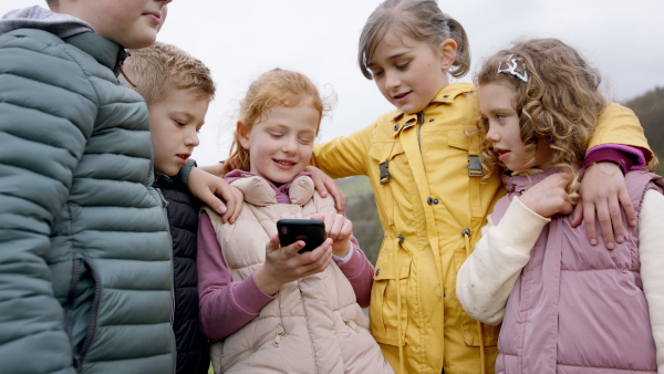 Group of small children outdoors in nature, looking for direction. Learning group education concept.