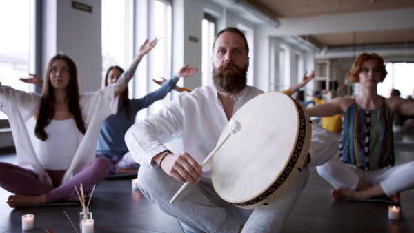 A group of people doing yoga exercises and meditating with candles.