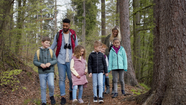 Teachers with group of small children outdoors in nature. Learning group education concept.