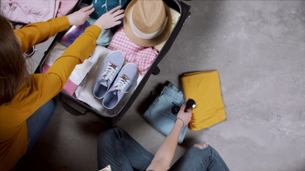 Top view of young couple packing for trip holiday, desktop travel concept.