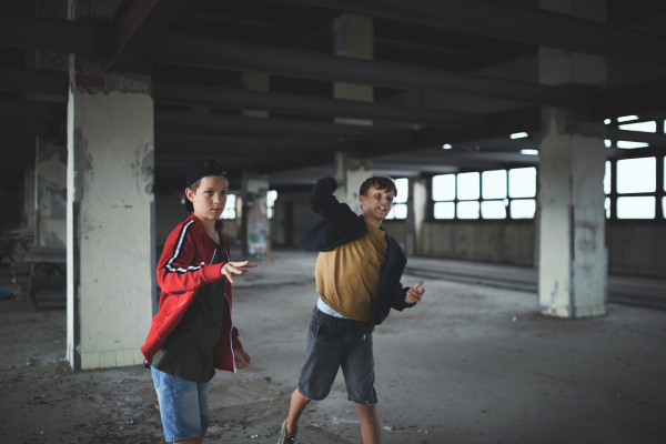 An attack of teenage boys thugs in abandoned building, gang violence and bullying concept.