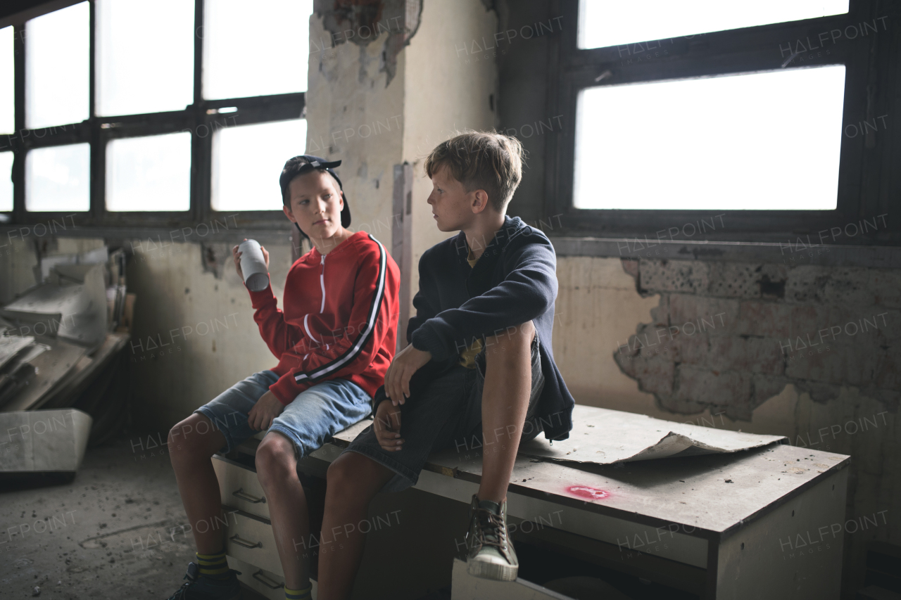 Group of teenagers boys gang indoors in abandoned building, talking.