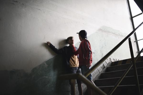 Teenage boy attacked by thug indoors in abandoned building, gang violence and bullying concept.