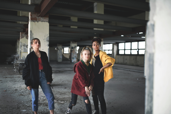 An attack of teenage girls thugs in abandoned building, gang violence and bullying concept.