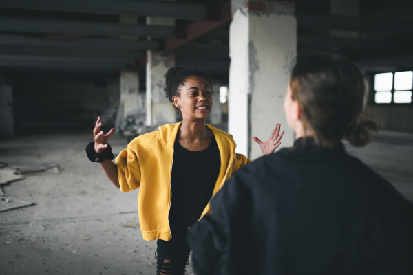 Scared teenage girl attacked by thugs in abandoned building, gang violence and bullying concept.