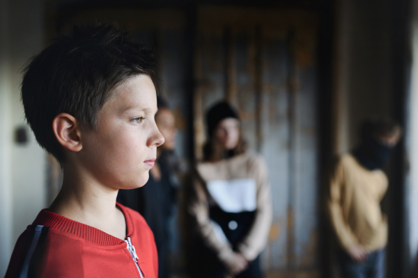 Sad and disappointed teenagers boy indoors in abandoned building, bullying concept. Copy space.