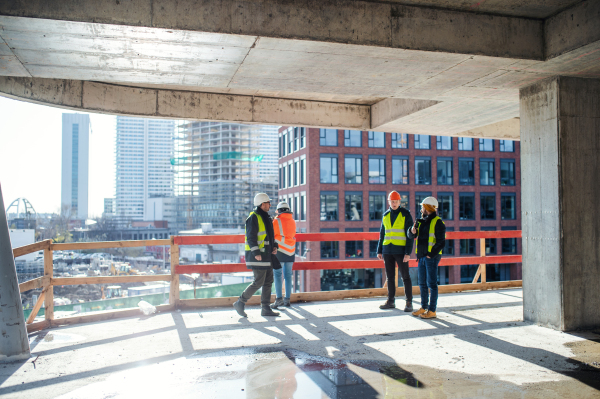 A group of engineers standing on construction site, talking.