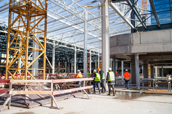 A group of engineers standing on construction site, talking.