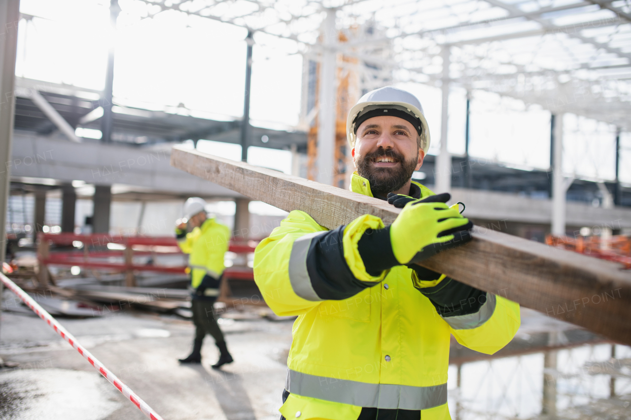 Men workers walking outdoors on construction site, working in winter.