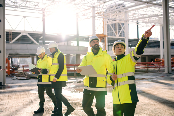 A group of engineers standing outdoors on construction site, working.