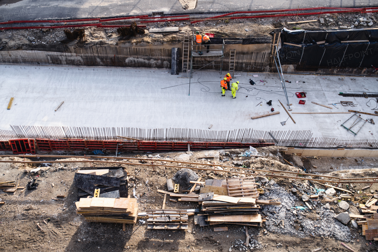 An aerial view of group of workers on construction site, working.