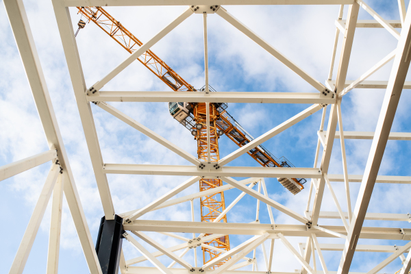 A construction site with steel frame structure and crane.