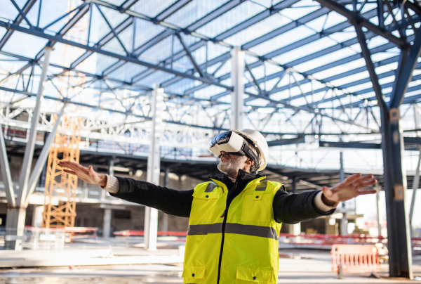 Man engineer using VR goggles outdoors on construction site.