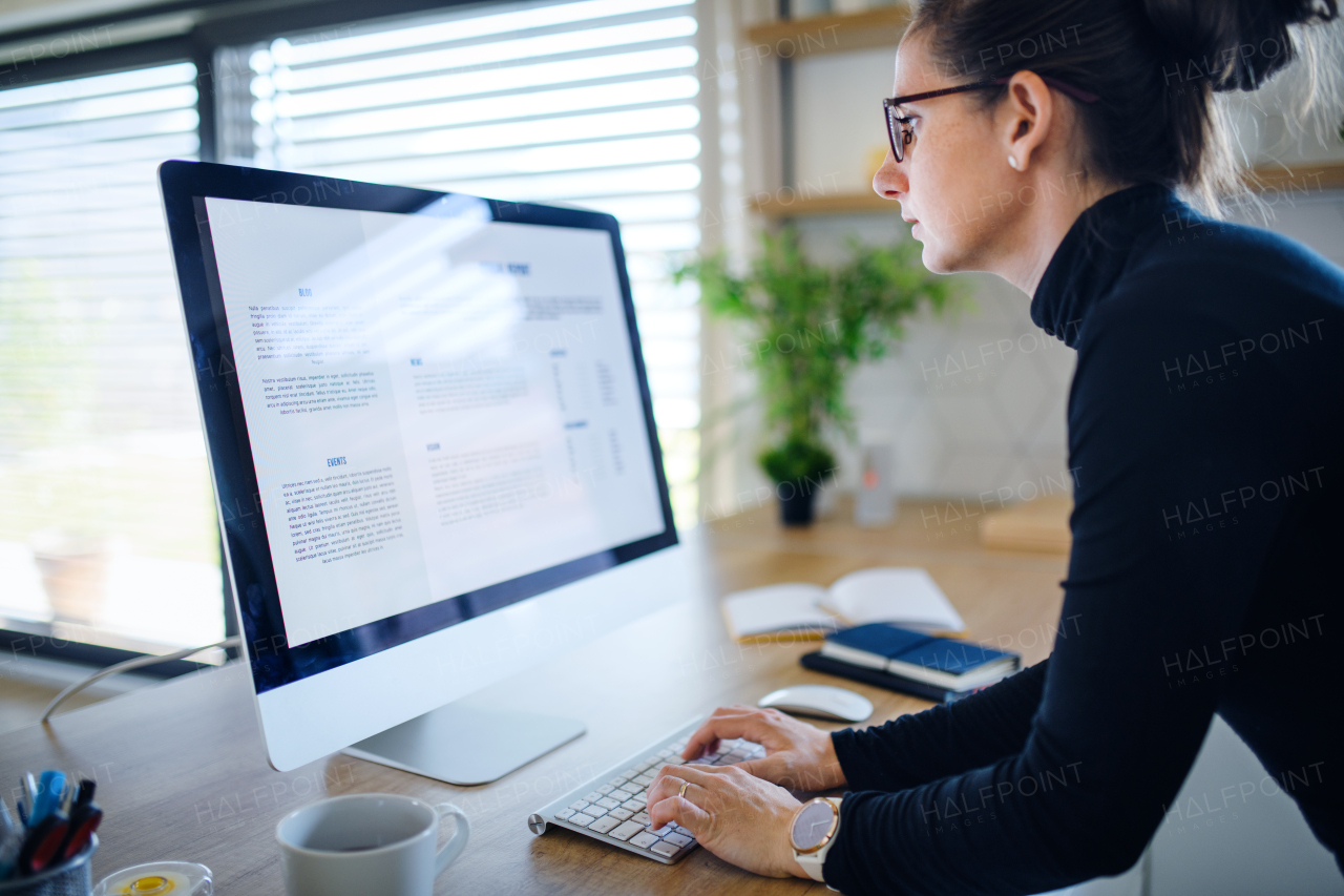 Young woman working indoors at home office, Corona virus and quarantine concept.