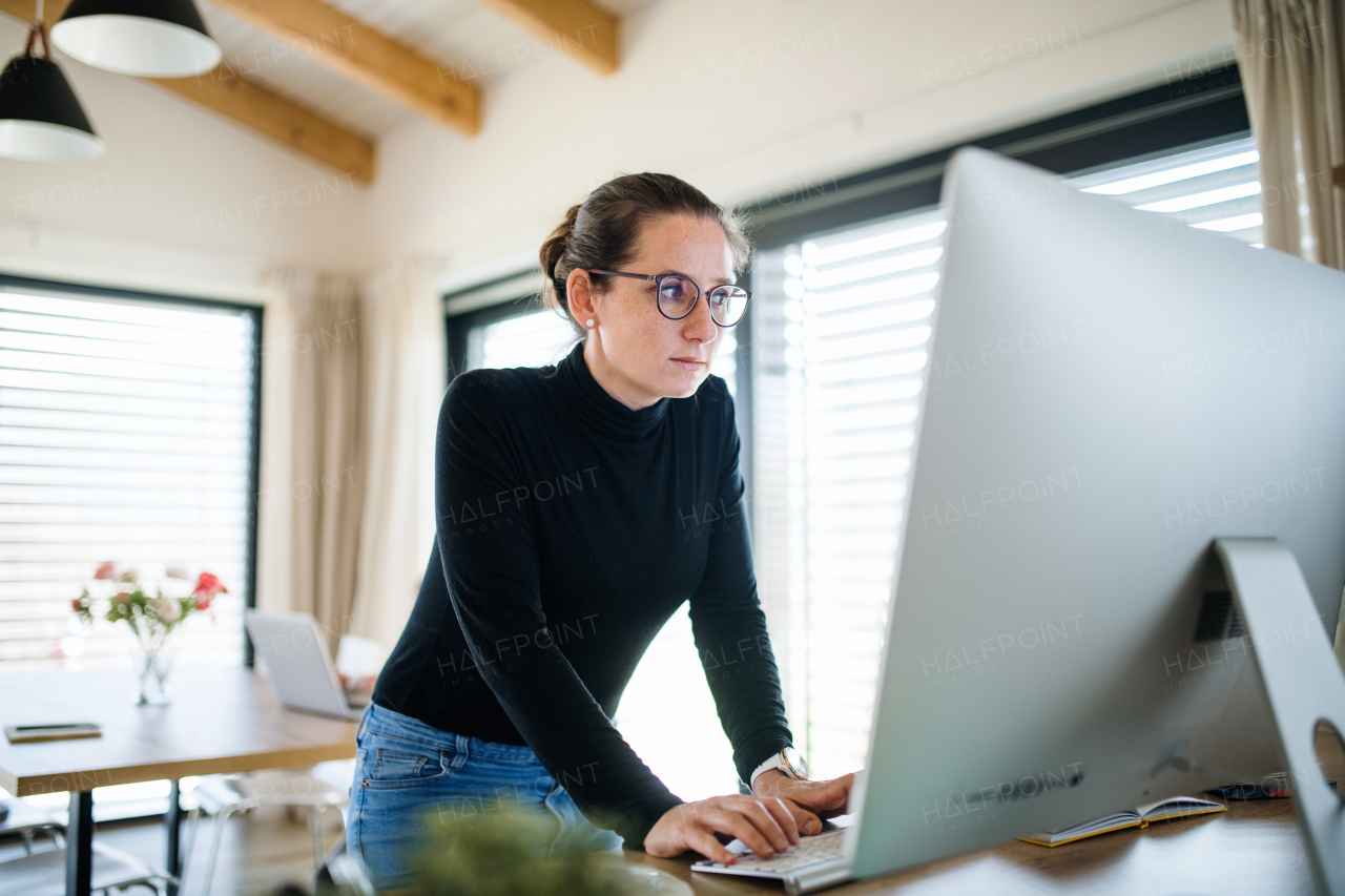 Woman with daughter working indoors at home office, Corona virus and quarantine concept.