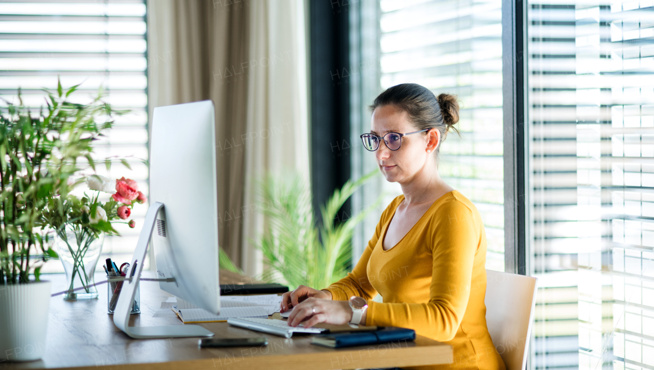 Woman with computer working indoors at home office, Corona virus and quarantine concept.