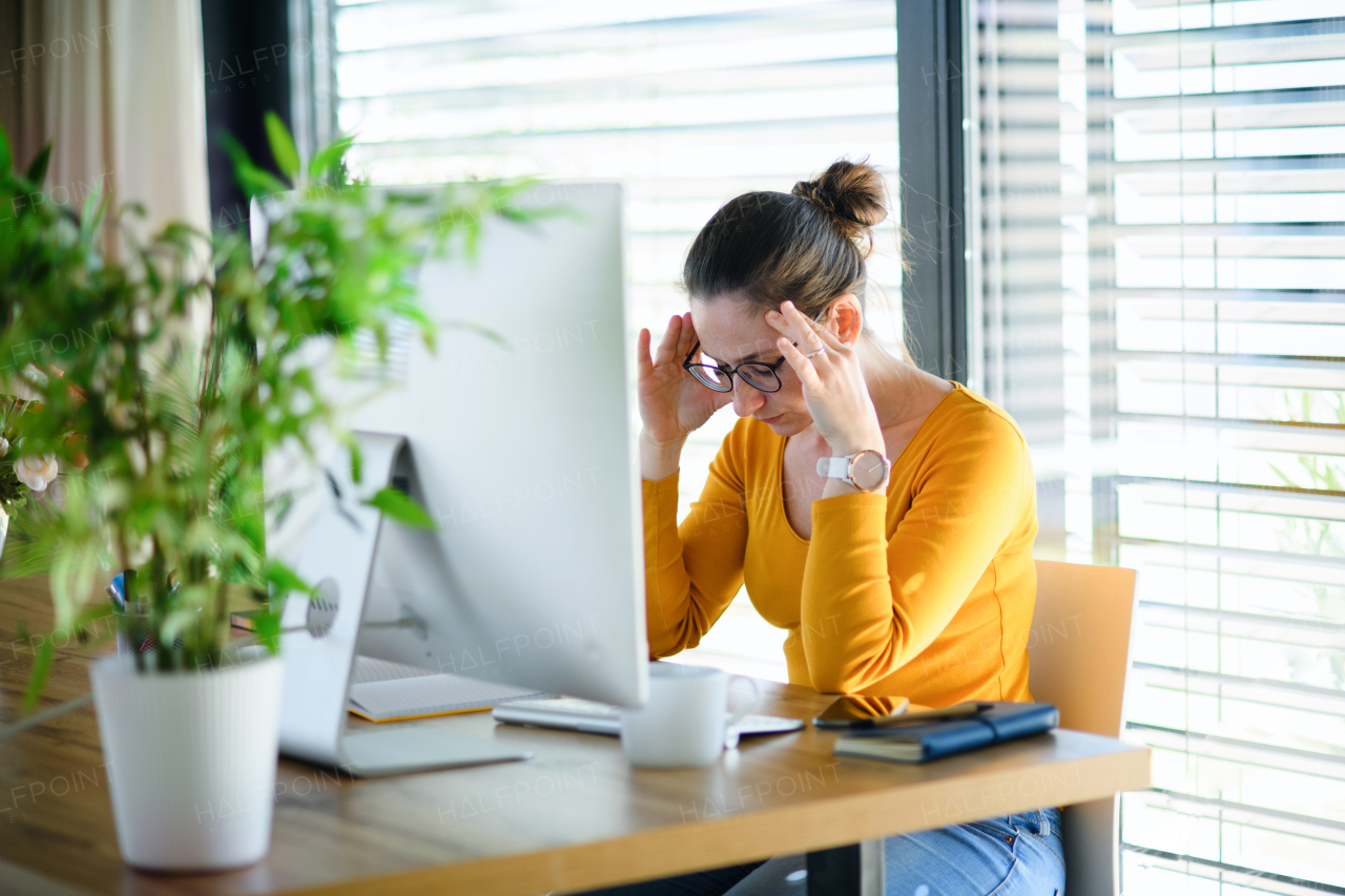 Worried woman working indoors at home office, Corona virus and quarantine concept.