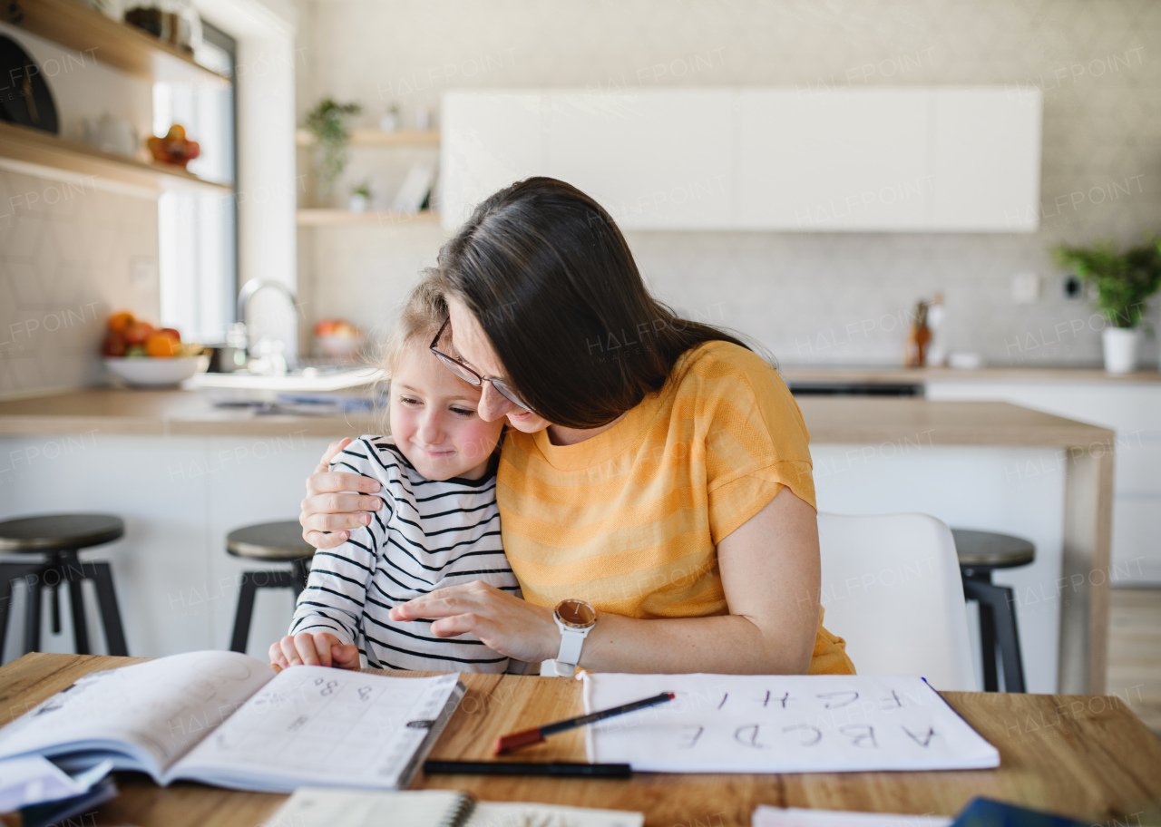 Mother and small daughter learning indoors at home, Corona virus and quarantine concept.