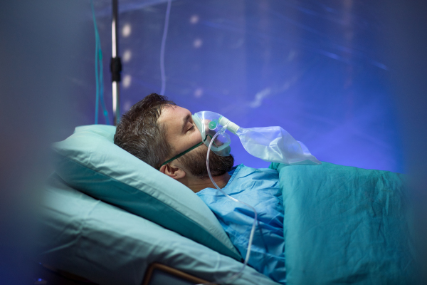 An infected patient in quarantine lying in bed in hospital, coronavirus concept.