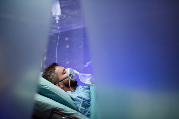 An infected patient in quarantine lying in bed in hospital, coronavirus concept.