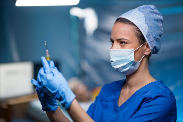 Woman doctor holding syringe in hospital, coronavirus concept.