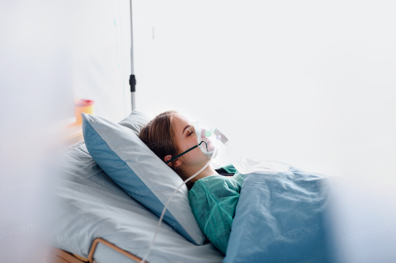 Young infected patient in quarantine lying in bed in hospital, coronavirus concept.