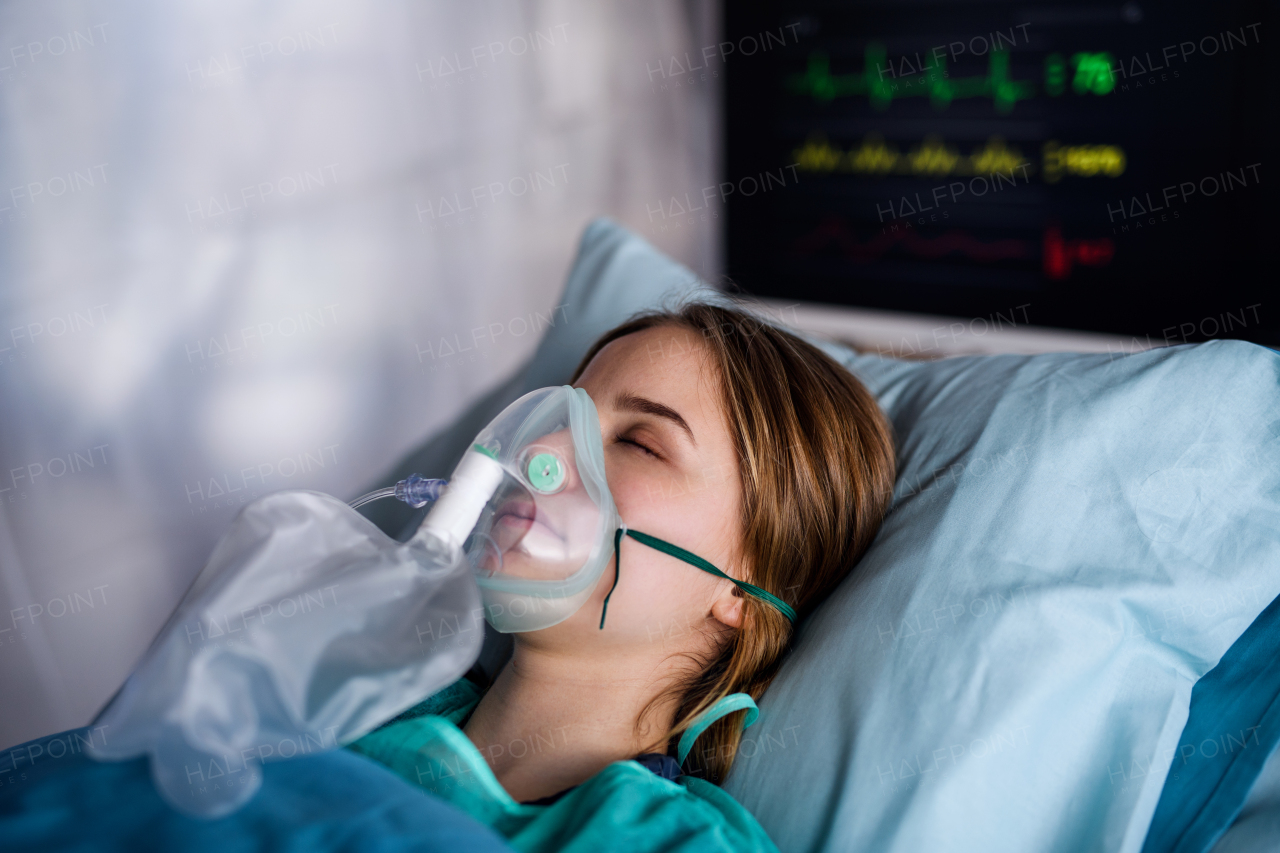 Young infected patient in quarantine lying in bed in hospital, coronavirus concept.