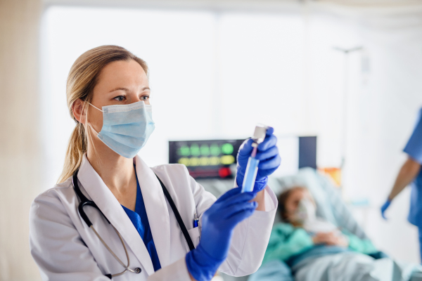 Portrait of doctor with syringe in quarantine in hospital, coronavirus concept.