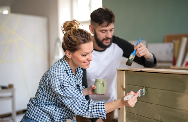 Happy mid adults couple painting furniture indoors at home, relocation and diy concept.