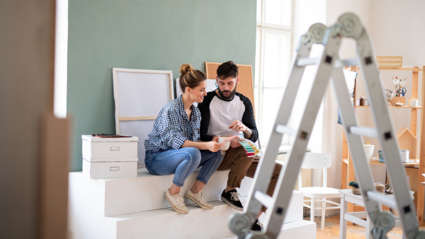 A mid adults couple with colour swatch indoors at home, relocation and diy concept.