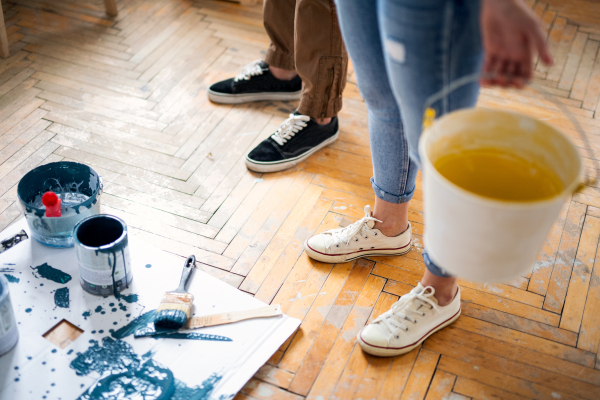 Unrecognizable mid adults couple painting wall indoors at home, relocation and diy concept.