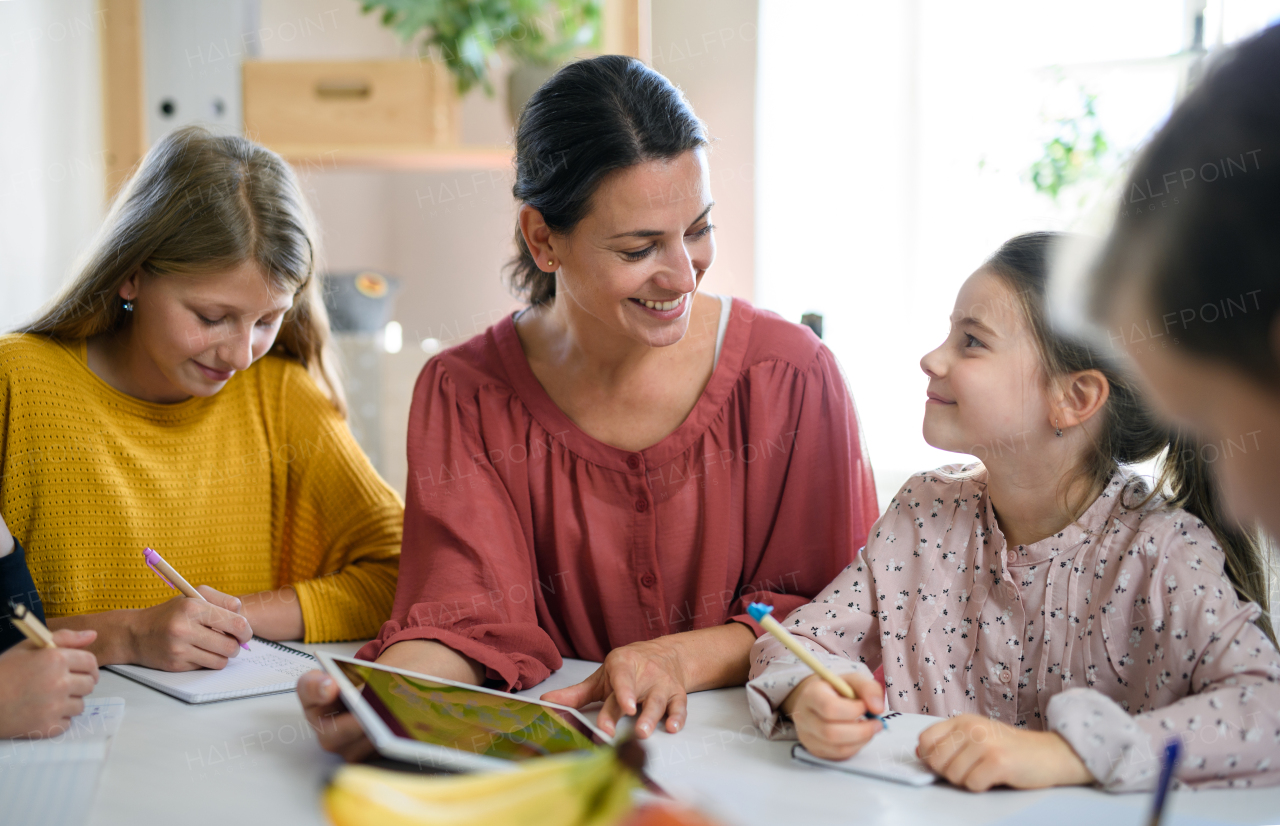 Group of homeschooling children with parent teacher studying indoors, coronavirus concept.