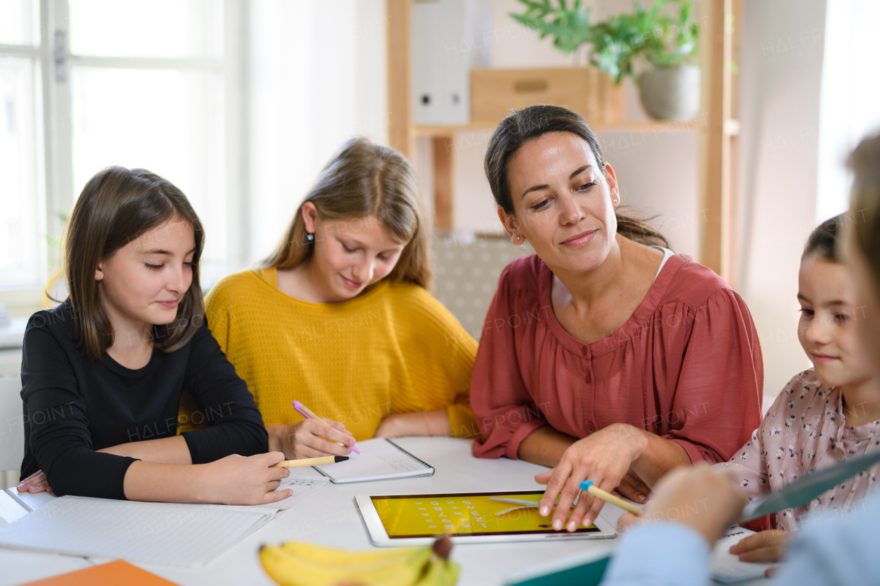 Group of homeschooling children with parent teacher studying indoors, coronavirus concept.