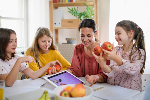 Group of homeschooling children with parent teacher studying indoors, coronavirus concept.