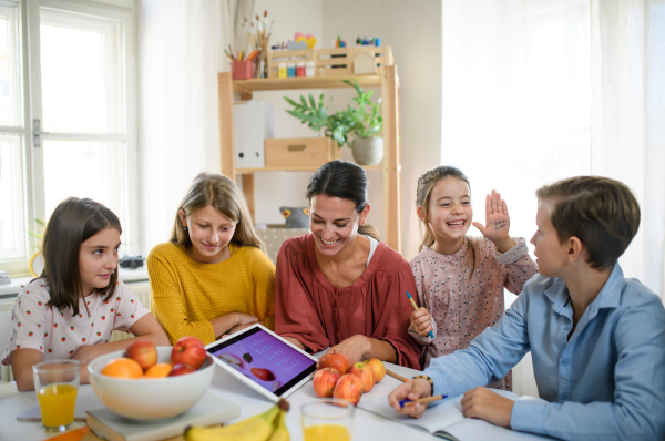 Group of homeschooling children with parent teacher studying indoors, coronavirus concept.