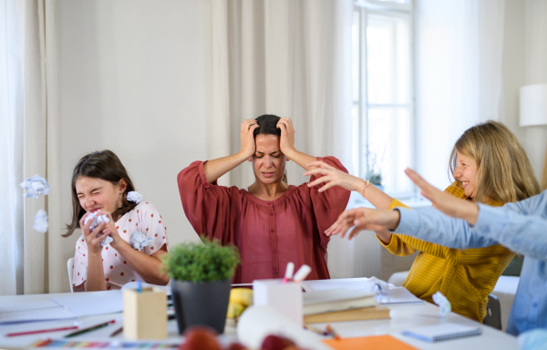 Group of misbehaving homeschooling children with unhappy teacher studying indoors, coronavirus concept.