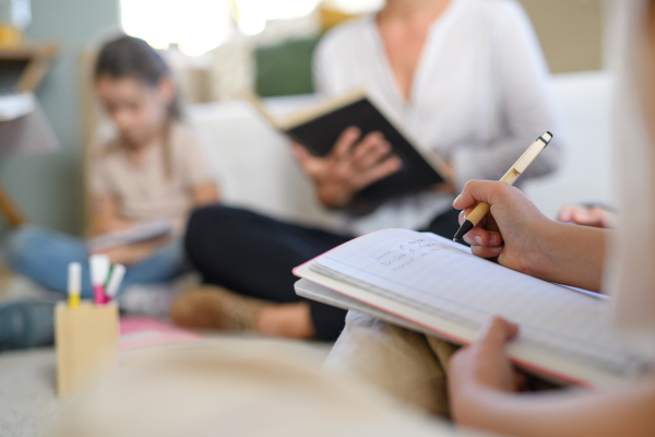 Group of homeschooling children with parent teacher studying indoors, coronavirus concept.