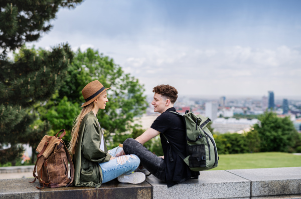 Portrait of young couple travelers with map in city on holiday, resting and planning.