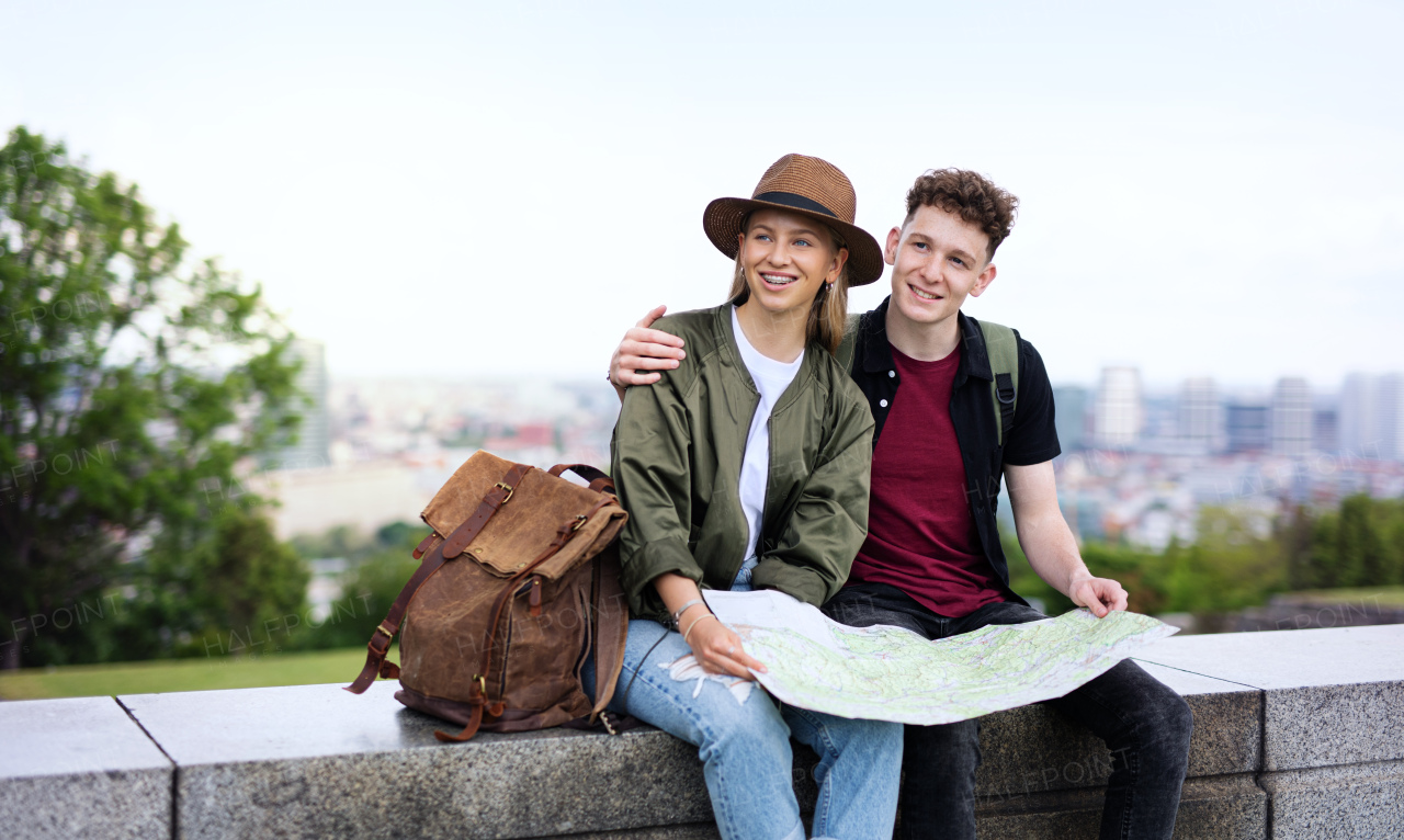 Portrait of young couple travelers with map in city on holiday, resting and planning.