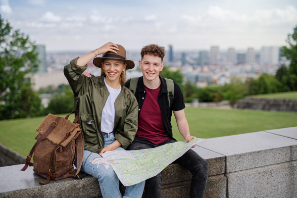 Portrait of young couple travelers with map in city on holiday, resting and camera.