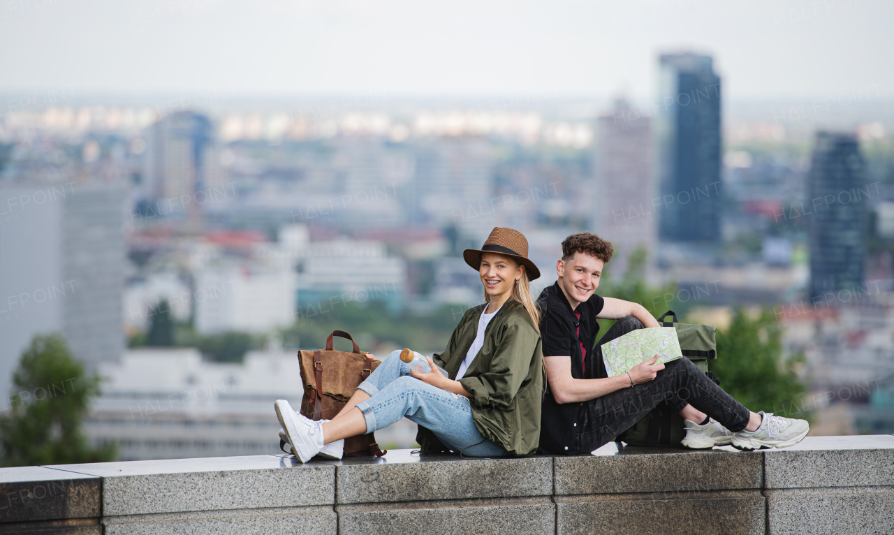 Portrait of young couple travelers with map in city on holiday, resting and camera.