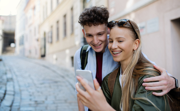 Young couple travelers walking with smarthone in city on holiday, sightseeing.