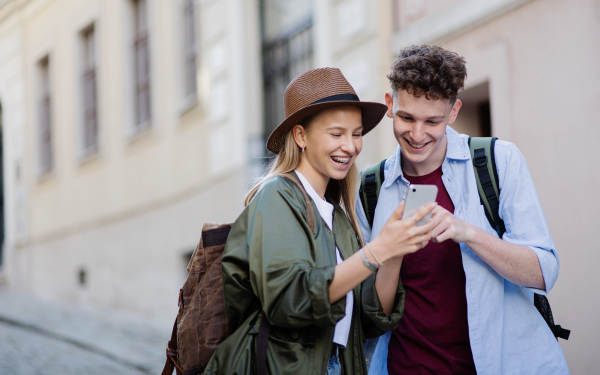 Young couple travelers walking with smarthone in city on holiday, sightseeing.